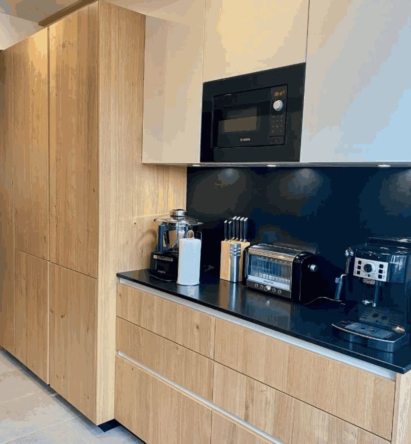 Bois brut, plan noir et électroménager encastré