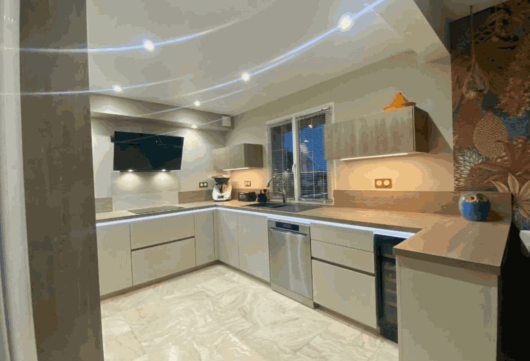 Cuisine en U taupe et bois, hotte design suspendue