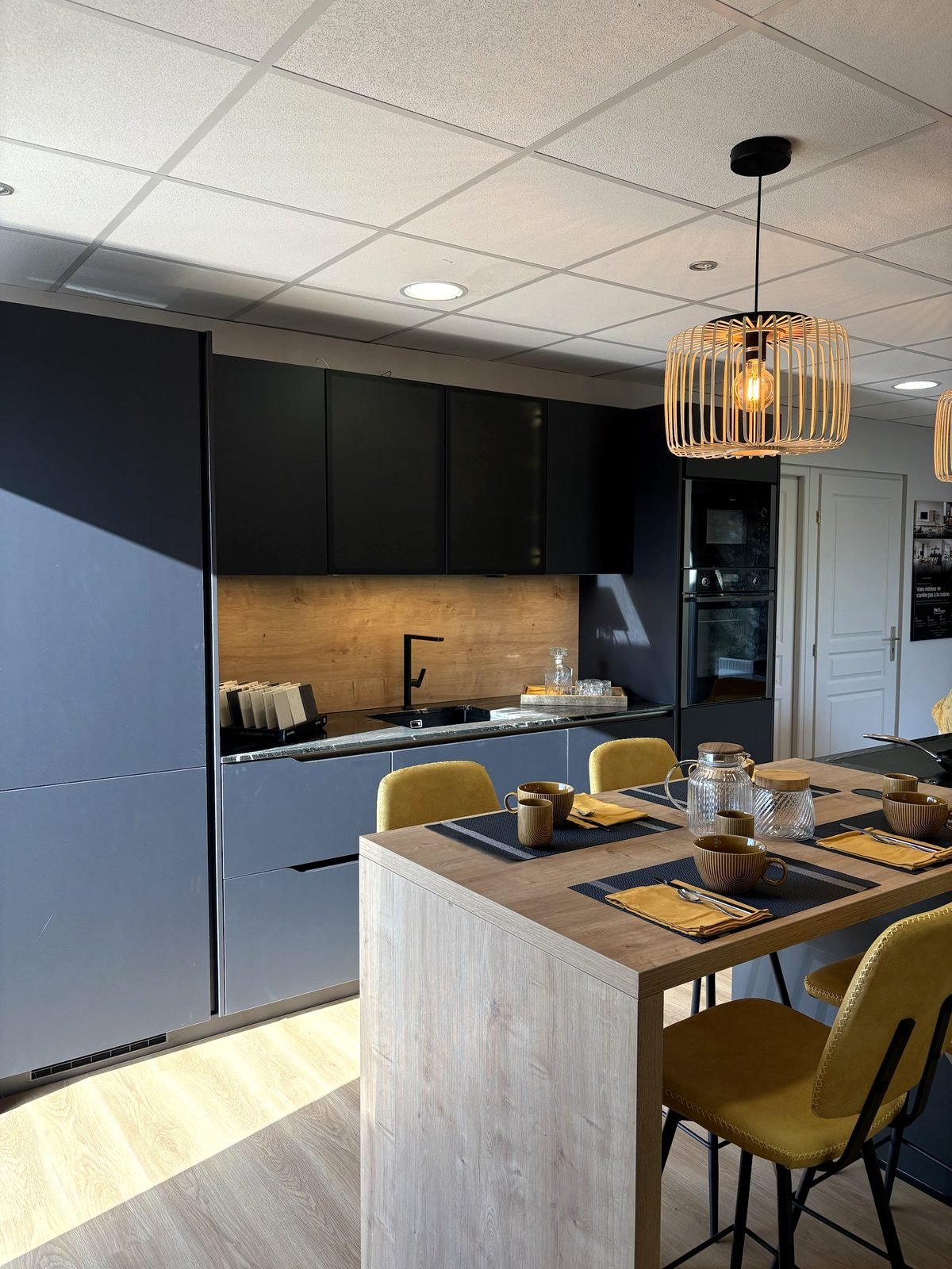 Colonne de fours encastrés et îlot bois au showroom Niko Cuisines